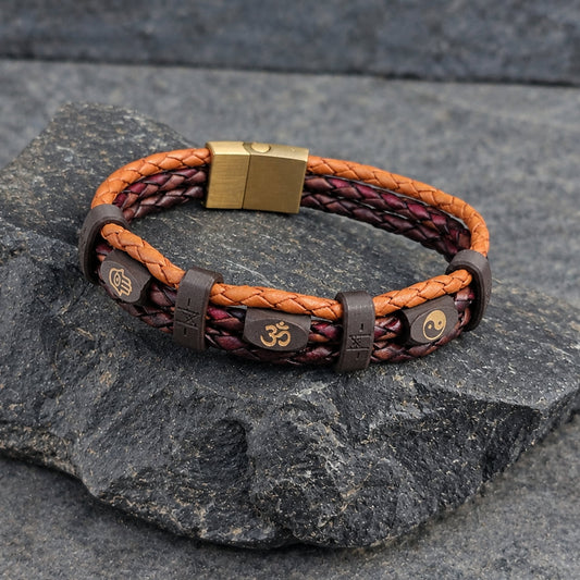 Mantra · Banded Leather in Tibet: tan leather outer braids · maroon centre braid · dark-brown beads · gold hamsa, om + yin yang · brown bands · brass slide-lock clasp