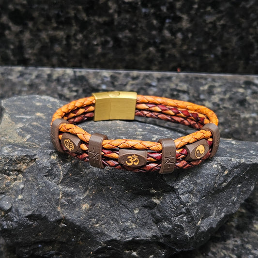 Mantra · Banded Leather in Tibet: tan leather outer braids · maroon centre braid · dark-brown beads · gold hamsa, om + yin yang · brown bands · brass slide-lock clasp